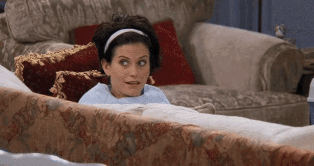 a woman is laying on a couch with a headband on her hair