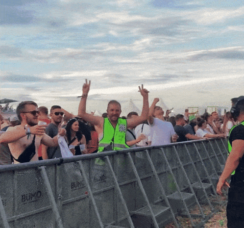 a bunch of people standing behind a barrier that says bumo