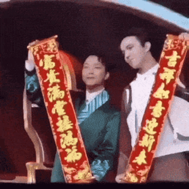 a man in a green suit holds up a red banner with chinese writing