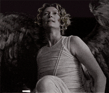 a woman in a white dress with angel wings on her back
