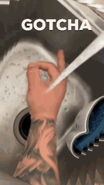 a person with a tattoo on their arm is washing their hands in a sink and the word gotcha is above them