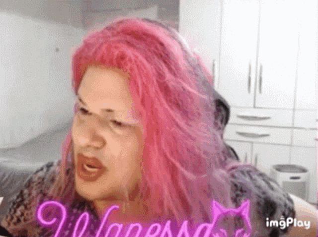 a woman with pink hair is wearing a wig and making a face .