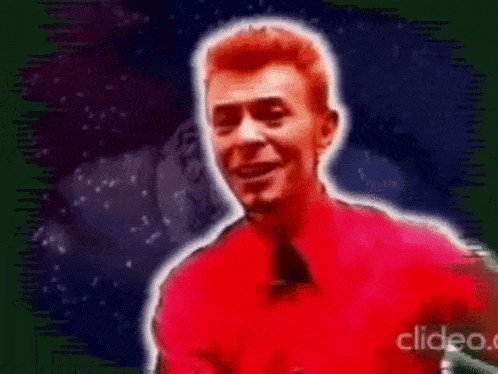 a man in a red shirt and tie is smiling in front of a green and blue background .