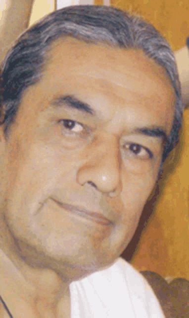 a close up of a man 's face with a white shirt on