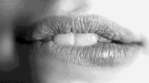 a black and white photo of a woman 's lips with lipstick on them .