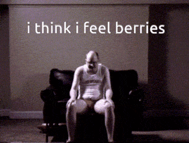 a man is sitting on a couch with the words " i think i feel berries " written above him