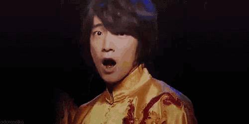 a young man is making a surprised face while holding his mouth open .