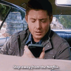a man is sitting in the back seat of a car looking at his phone and saying " step away from the netflix "