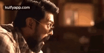 a man with a beard and glasses is making a face .