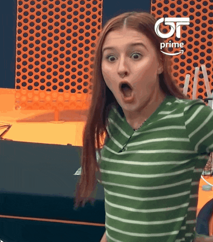 a girl with a surprised look on her face is wearing a green and white striped shirt sponsored by amazon prime