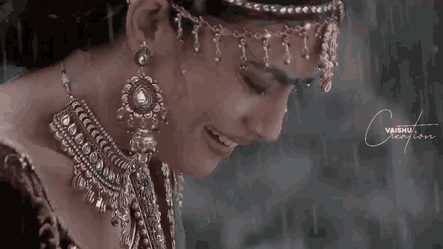 a woman wearing a necklace and earrings smiles in the rain .