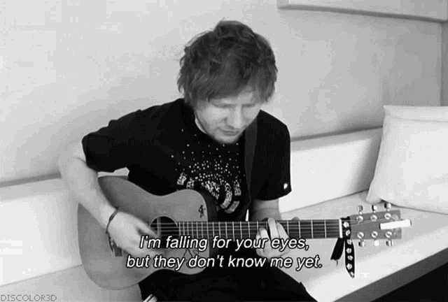 a black and white photo of a man playing a guitar