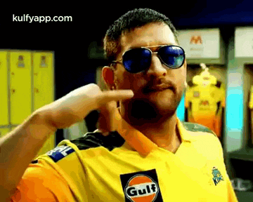 a man wearing sunglasses and a yellow shirt that says gulf on it