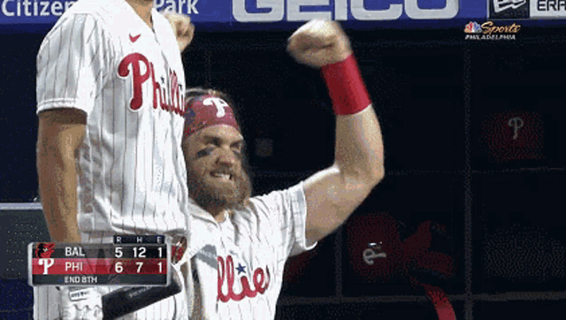 a philadelphia phillies baseball player holds up his fist in the air