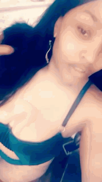 a woman in a bra is taking a selfie with her phone .