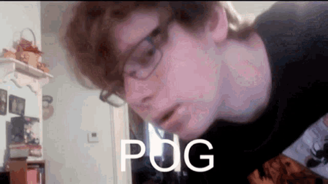 a young man wearing glasses and a black shirt has the word pog written on his face .