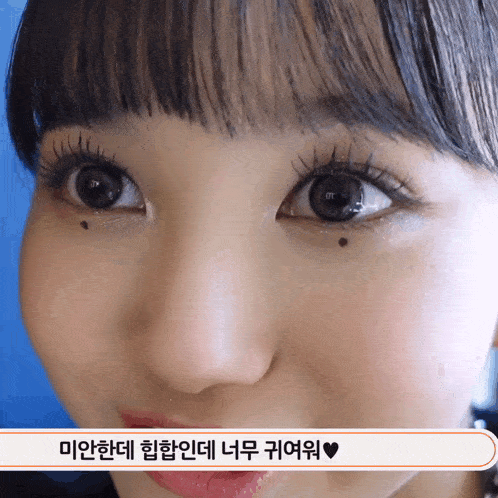a close up of a girl 's face with korean writing on the bottom