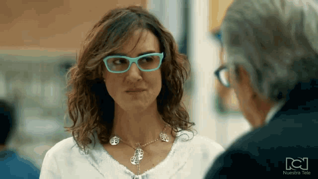 a woman wearing glasses and a necklace with a tree of life pendant