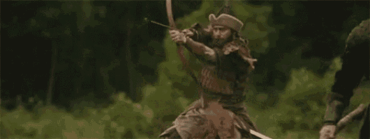 a man is riding on the back of a horse and aiming a bow and arrow .