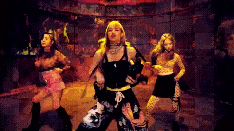 a group of girls are dancing in a dark room .