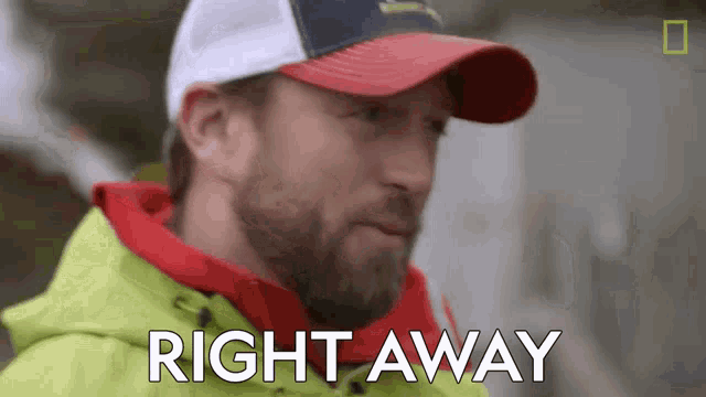 a man wearing a hat and a yellow jacket is saying right away