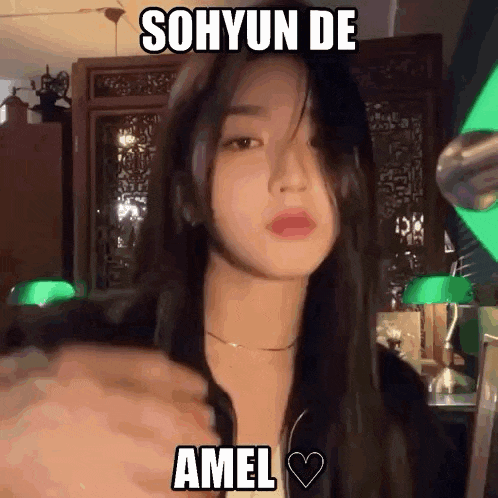 a woman with long black hair is taking a selfie with a green light behind her .