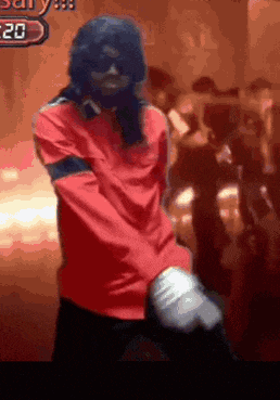 a man in a red shirt is dancing in front of a sign with the number 20 on it