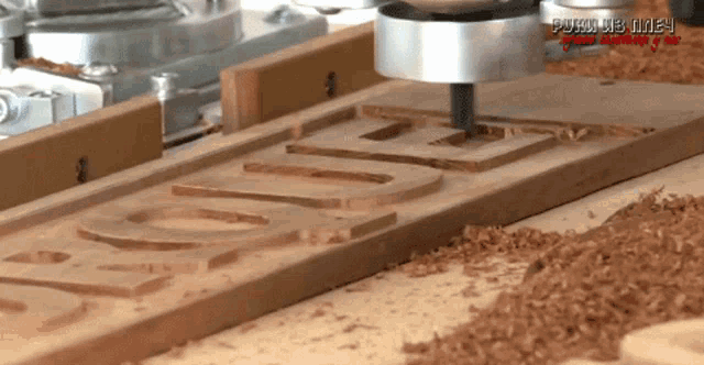a machine is cutting a piece of wood that says love