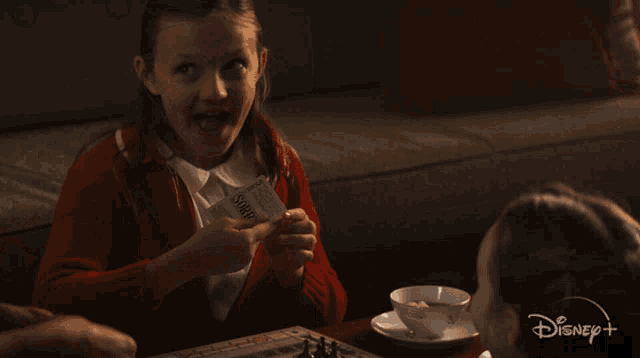 a girl is holding a piece of paper that says ' savings ' on it