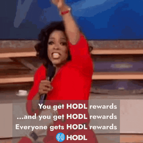 a woman in a red shirt is holding a microphone in front of a sign that says you get hodl rewards