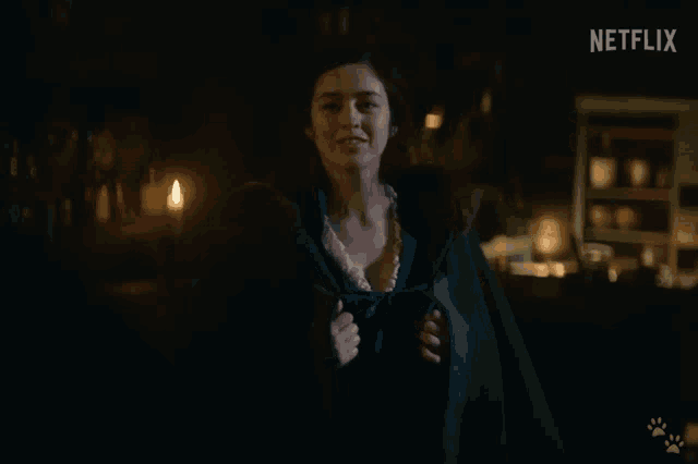 a woman stands in a dark room with a netflix logo in the corner