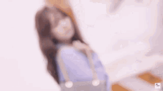 a woman in a blue shirt is laying on a bed with a purse .