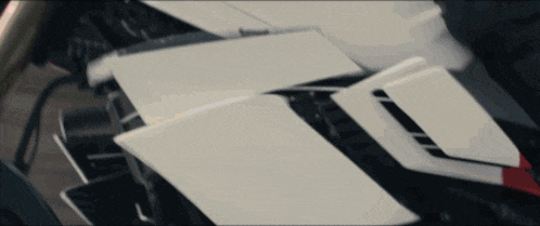 a close up of a white motorcycle with a black and red stripe on the side