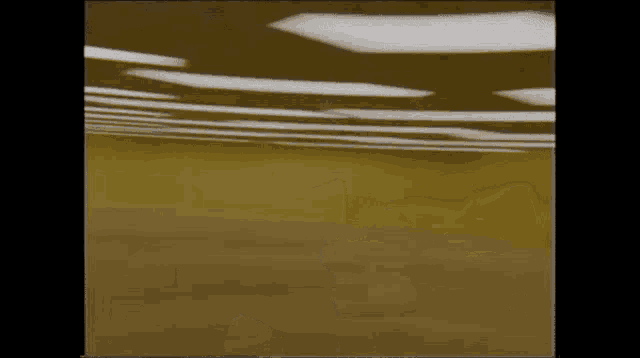 a blurry picture of a room with a yellow floor and white lights