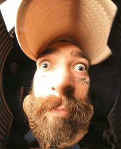 a man with a beard and a hat has a tattoo on his face that says coffee