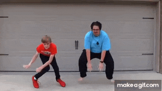 two young men are dancing in front of a garage door .