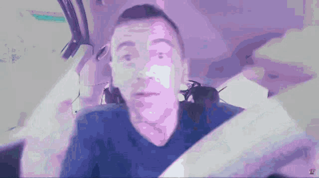 a man in a blue shirt is sitting in a car with the letter z on the bottom