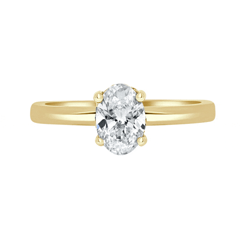a yellow gold ring with an oval shaped diamond in the center