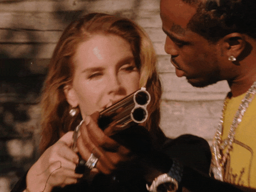 a man and a woman are looking at a gun that has two barrels