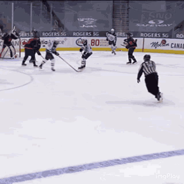 a hockey game is being played on a ice rink with ads for rogers sg