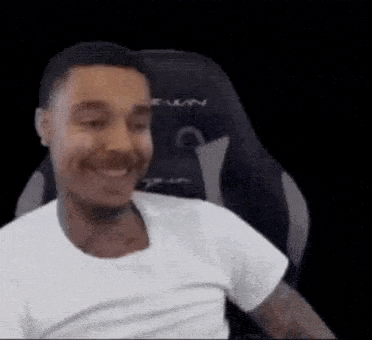 a man is smiling while sitting in a gaming chair .