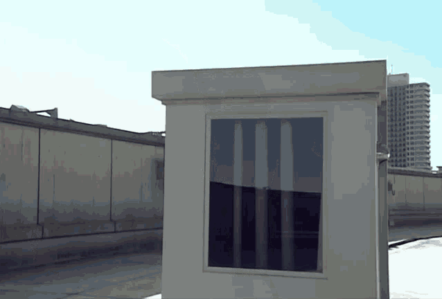 a small white building with a window on the side