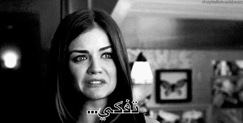 a black and white photo of a woman crying with arabic writing on her face