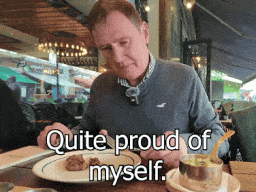 a man is sitting at a table with a plate of food and the words quite proud of myself