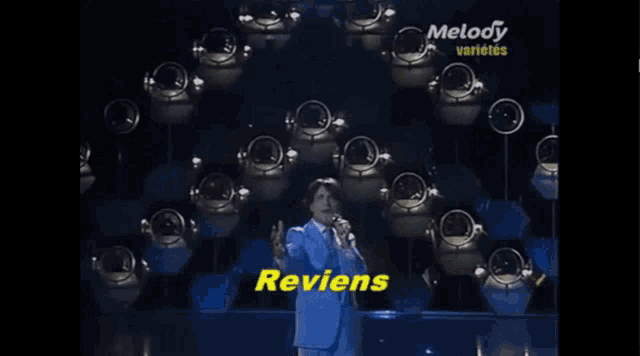 a man singing into a microphone in front of a melody variety banner