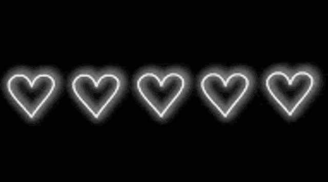 a row of white hearts are glowing on a black background .