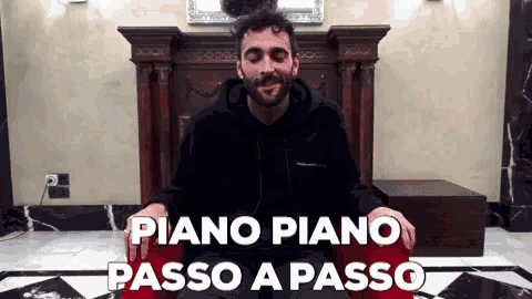a man with a beard is sitting in a chair with the words piano piano passo a passo behind him