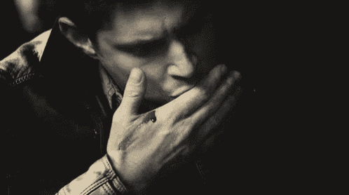 a man is covering his mouth with his hand