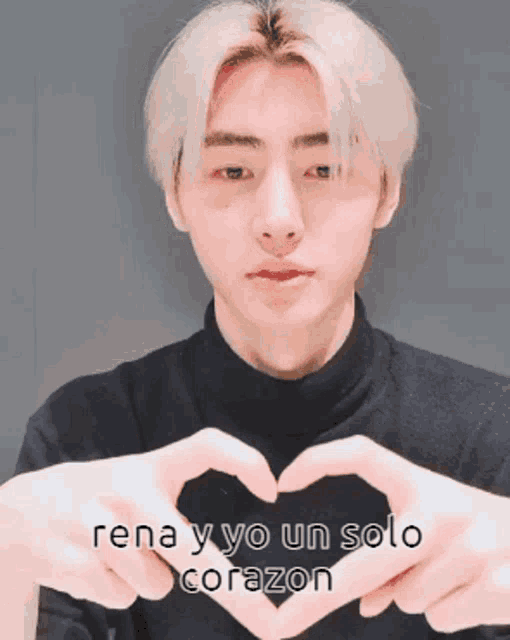a young man is making a heart shape with his hands with the words rena y yo un solo corazon below him