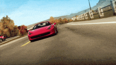 a red sports car is driving down the road